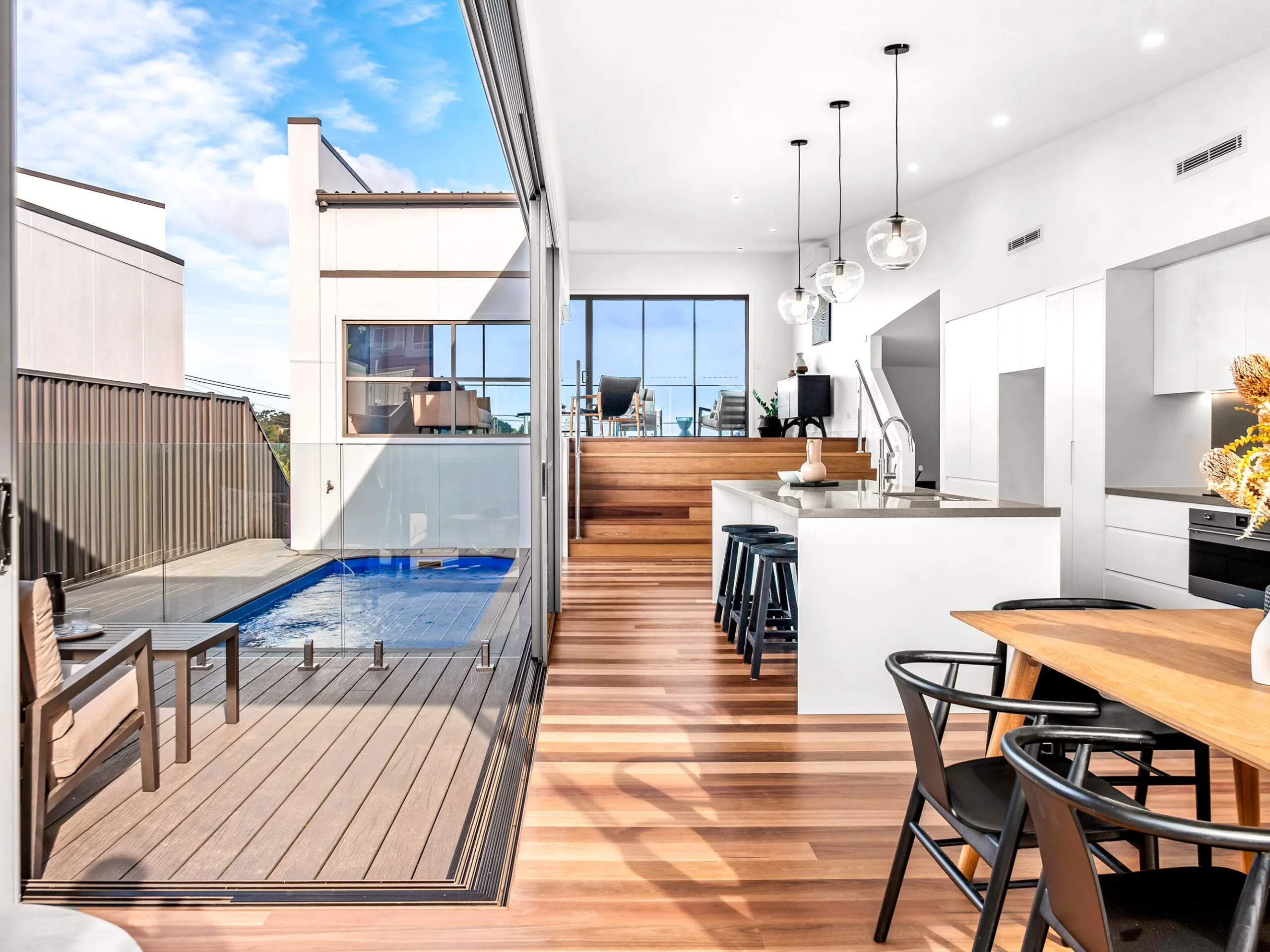 Plunge pool beside a modern kitchen and dining space